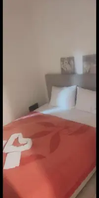 a bed with a red blanket on top of it at Stan Rafailovici LM in Rafailovici