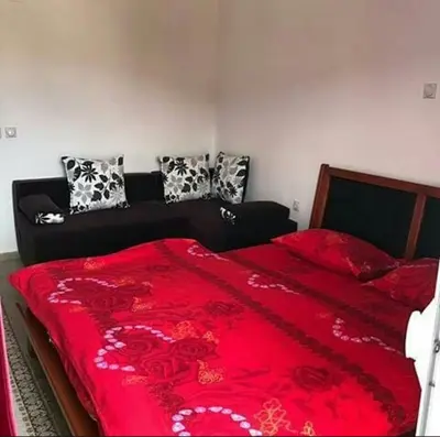 a bedroom with a red bed with red sheets and pillows at Mediterano Apartments in Ulcinj
