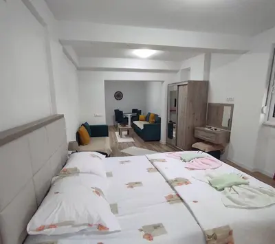 a bedroom with two beds and a living room at Mediterano Apartments in Ulcinj