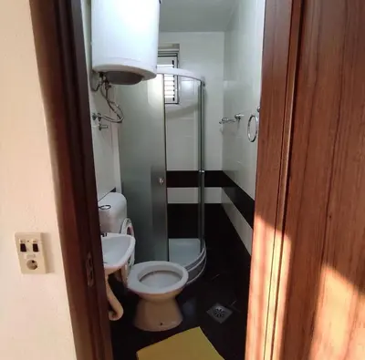 a bathroom with a toilet and a glass shower at Mediterano Apartments in Ulcinj