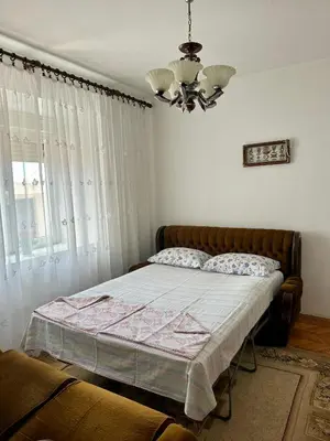 a bedroom with a bed and a chandelier at Nimanbegu Apartments in Ulcinj
