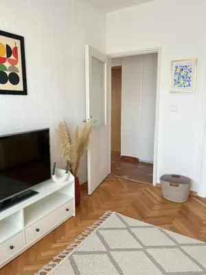 a living room with a flat screen tv on a cabinet at Cozy & Sunny 2-bedroom in best location in the city in Podgorica