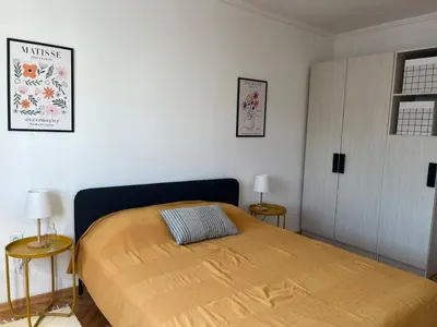 a bedroom with a bed with two tables and two lamps at Cozy & Sunny 2-bedroom in best location in the city in Podgorica