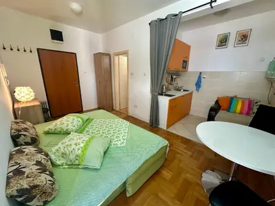 a small room with a bed and a kitchen at Happy Time Studio in Petrovac na Moru