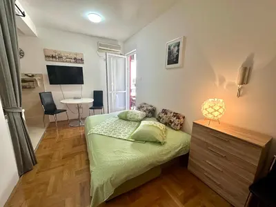 a bedroom with a bed and a table with chairs at Happy Time Studio in Petrovac na Moru