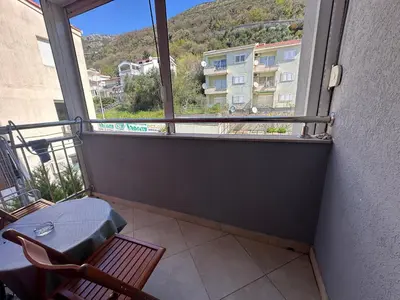 a balcony with a table and a chair and a window at Happy Time Studio in Petrovac na Moru