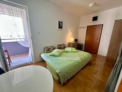 a bedroom with a bed and a table and a window at Happy Time Studio in Petrovac na Moru