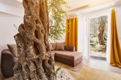 a living room with a couch and a tree at Eman Resort & Villas in Ulcinj