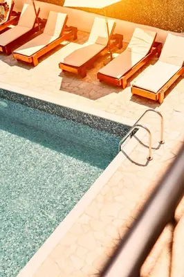 a pool with chaise lounge chairs and a swimming pool at Eman Resort & Villas in Ulcinj
