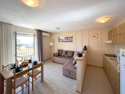 a kitchen and living room with a couch and a table at Sun&Sea Petrovac in Petrovac na Moru