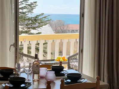 a table with glasses and a bottle of wine on a balcony at Sun&Sea Petrovac in Petrovac na Moru