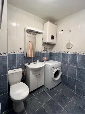 a bathroom with a toilet a sink and a washing machine at Sun&Sea Petrovac in Petrovac na Moru