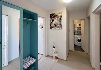 a hallway with a blue door and a laundry room at Sun&Sea Petrovac in Petrovac na Moru