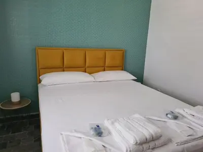 a bedroom with a bed with white sheets and towels at Casa-Cristiano in Sutomore