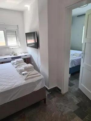 a bedroom with two beds and a sink and a mirror at Casa-Cristiano in Sutomore