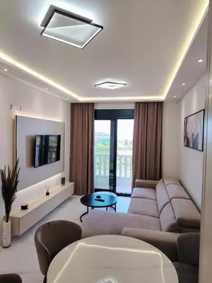 a living room with a couch and a tv at Seratlić Lux 27 in Bar