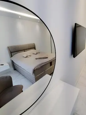 a mirror reflecting a bed in a room at Seratlić Lux 27 in Bar