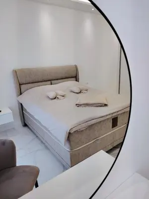 a mirror reflecting a bed in a room at Seratlić Lux 27 in Bar