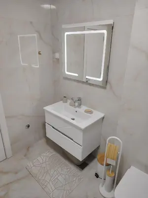 a white bathroom with a sink and a mirror at Seratlić Lux 27 in Bar
