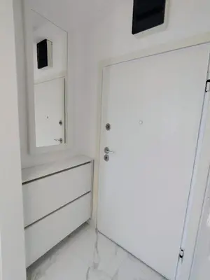 a white room with a door and a mirror at Seratlić Lux 27 in Bar