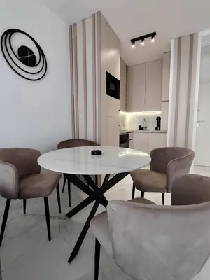 a dining room with a white table and chairs at Seratlić Lux 27 in Bar