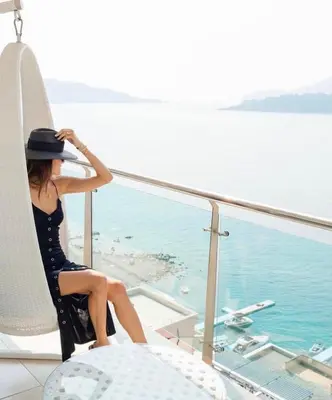 a woman sitting on a cruise ship looking out at the water at Hotel Ponta Nova in Budva