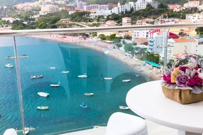 a balcony with a view of a beach and water at Hotel Ponta Nova in Budva