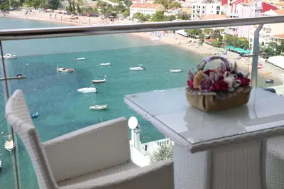 a balcony with a basket of flowers on a table at Hotel Ponta Nova in Budva
