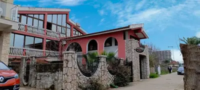 a red building with a stone fence in front of it at Kolovic Susanj in Bar