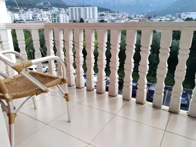 a chair on a balcony with a view of a city at Kolovic Susanj in Bar
