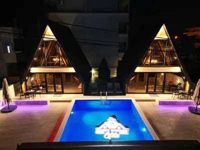 a building with a swimming pool in front of a building at Guest Houses Edita in Donji Štoj