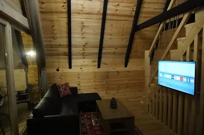 a living room with a couch and a flat screen tv at Guest Houses Edita in Donji Štoj