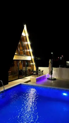 a large swimming pool at night with a house at Guest Houses Edita in Donji Štoj