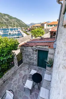 a patio with a table and chairs on a building at Apartment NICO in Kotor