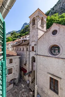 an old building with a clock tower on a street at Apartment NICO in Kotor