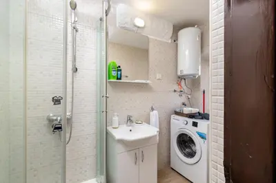 a bathroom with a sink and a washing machine at Apartment NICO in Kotor