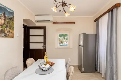 a kitchen and dining room with a table and a refrigerator at Apartment NICO in Kotor