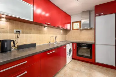 a red kitchen with a sink and a dishwasher at Historic Waterfront House in Muo
