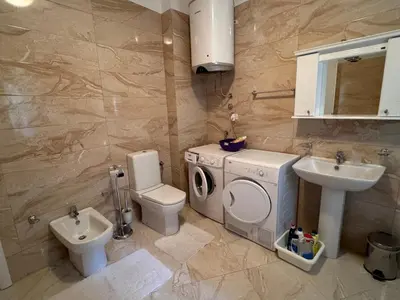 a bathroom with a washing machine and a sink at Apartament Rafailovici Budva in Budva
