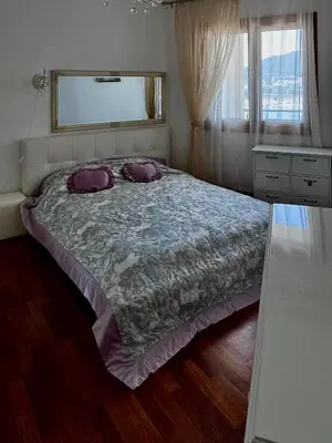 a bedroom with a bed with two pillows on it at Apartament Rafailovici Budva in Budva