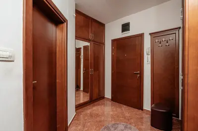 a hallway with wooden doors and a walk in closet at Adriatic Lux Apartment in Bar