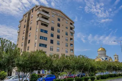 a tall building next to a building with a dome at Adriatic Lux Apartment in Bar