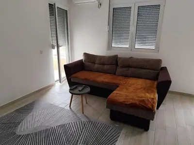 a living room with a brown couch in a room at Big Blue Apartment in Ulcinj