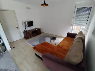 a living room with a couch and a table at Big Blue Apartment in Ulcinj