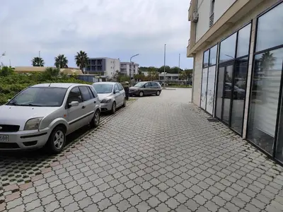 two cars parked in a parking lot next to a building at Big Blue Apartment in Ulcinj