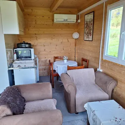 a living room with couches and a table and a kitchen at Cottage Kolomza in Ulcinj