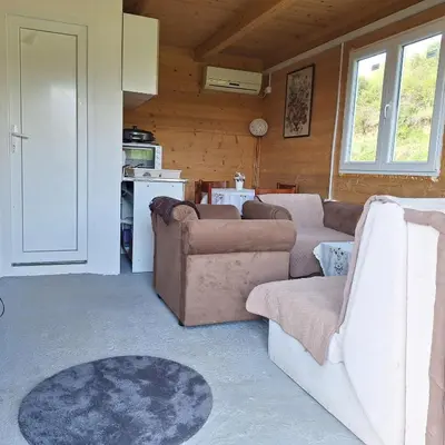 a living room with two couches and a kitchen at Cottage Kolomza in Ulcinj