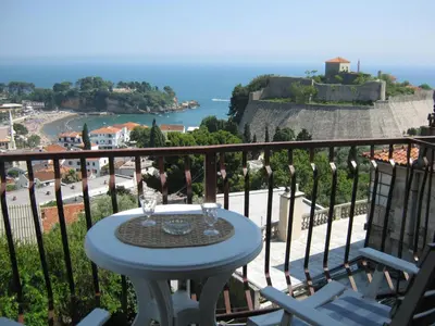 a table on a balcony with a view of the ocean at Apartment Olimp Ulcinj in Ulcinj