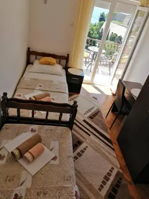 two beds in a room with a large window at Apartment Olimp Ulcinj in Ulcinj