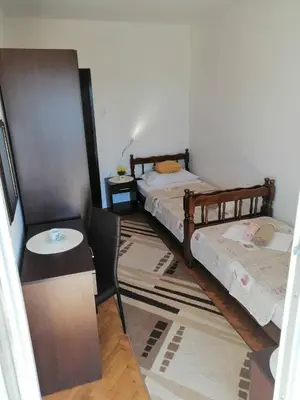 a room with two beds and a table and a table at Apartment Olimp Ulcinj in Ulcinj